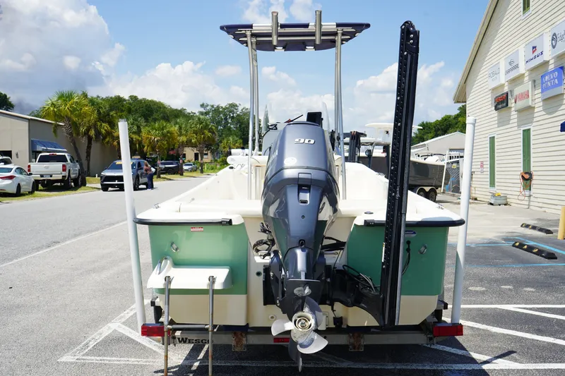 Slide: The Image of 2015 Key West 197 Skiff boat with outboard motor, parked outdoors on a sunny day. - 4