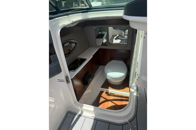 Slide: The Image of 2020 Chaparral 257 SSX boat interior with compact bathroom and modern amenities. - 16