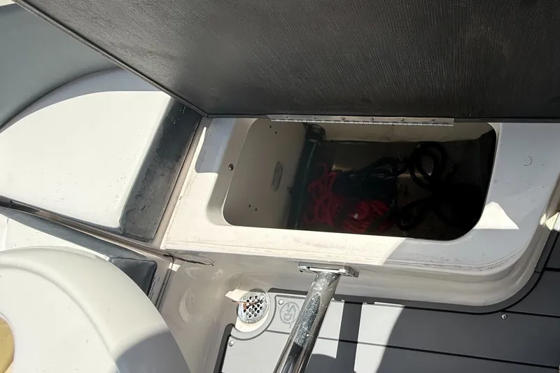 Slide: The Image of Open storage compartment on 2020 Chaparral 257 SSX boat, containing ropes. - 24