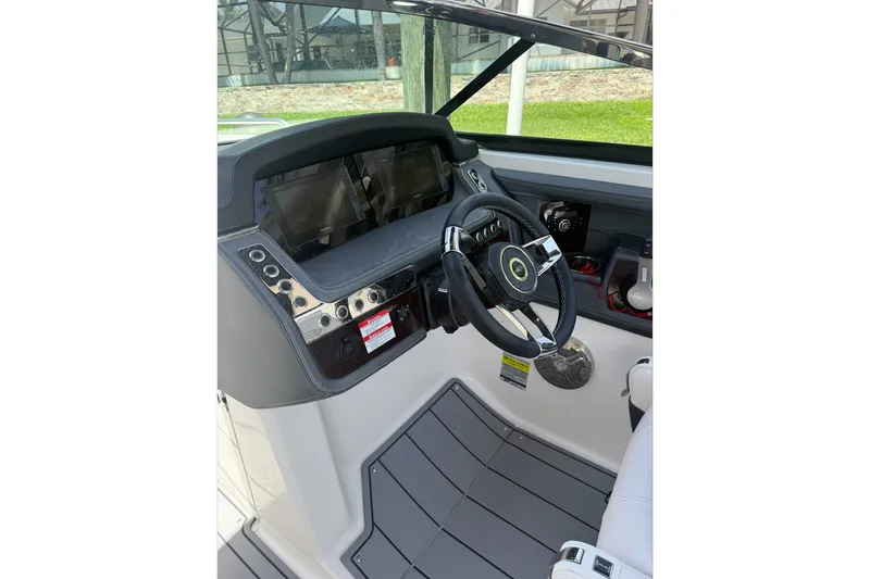 Slide: The Image of 2020 Chaparral 257 SSX boat dashboard with steering wheel and control panels. - 11