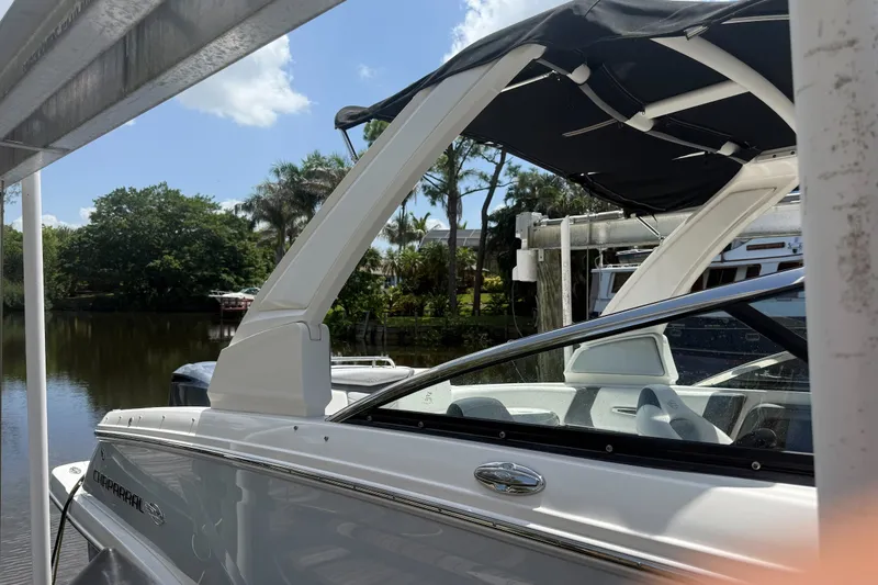Slide: The Image of 2020 Chaparral 257 SSX boat docked by a scenic river with lush greenery. - 2