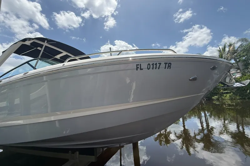 Slide: The Image of 2020 Chaparral 257 SSX boat docked under a sunny sky with reflections on water. - 1
