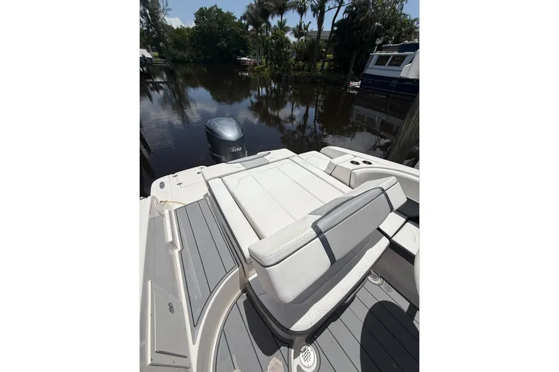Slide: The Image of 2020 Chaparral 257 SSX boat with sleek seating and powerful outboard motor on a calm river. - 10
