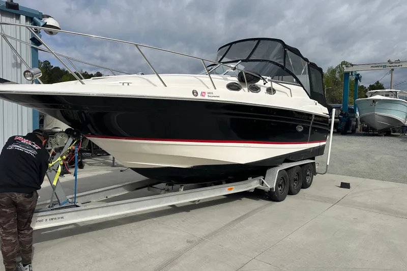 The Image of 2006 Regal Commodore 2765 boat on trailer at marina, overcast sky. - 1