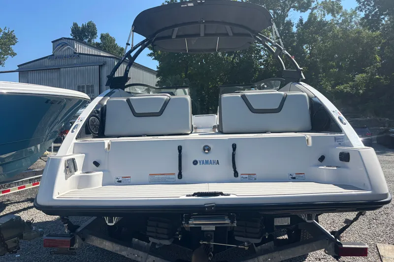 Slide: The Image of 2023 Yamaha Boats AR250 rear view on trailer, showcasing seating and design. - 5