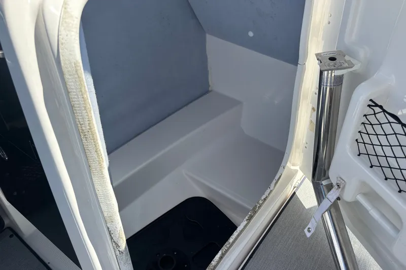 Slide: The Image of 2023 Yamaha Boats AR250 interior storage compartment with netting and metal support. - 18