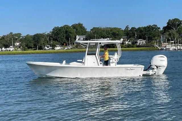 Slide: The Image of 2026 Pair Customs 24 Center Console MV boat on calm water, with scenic shoreline background. - 14
