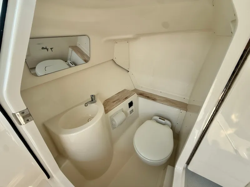 Slide: The Image of The image shows a clean, modern boat bathroom with a sink, toilet, and mirror. - 17