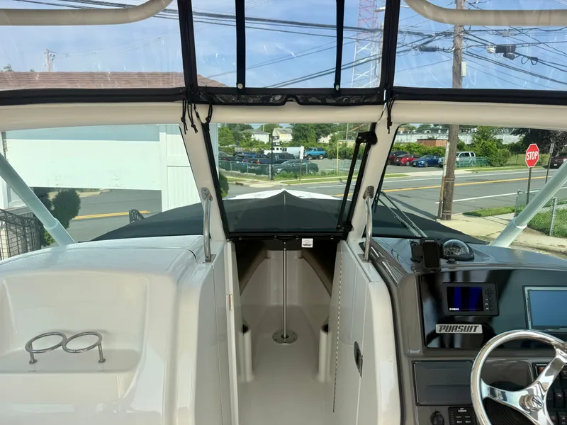 Slide: The Image of The image shows the cockpit of a 2019 Pursuit DC 265 Dual Console. It features a modern dashboard and clear forward view. - 22