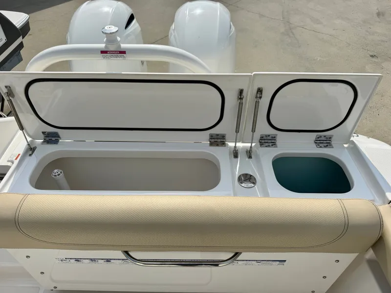 Slide: The Image of The image shows the rear area of a Pursuit DC 265 Dual Console boat with two open storage compartments. - 26