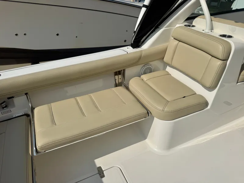 Slide: The Image of The interior of a 2019 Pursuit DC 265 Dual Console with beige upholstery. - 8