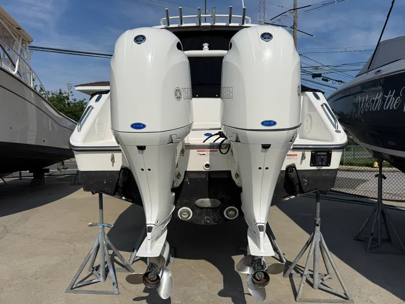 Slide: The Image of A 2019 Pursuit DC 265 Dual Console with twin outboard engines on a dry dock. - 2