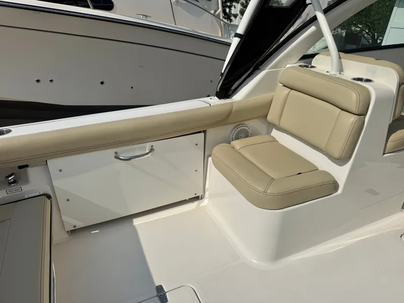 Slide: The Image of Interior view of a 2019 Pursuit DC 265 Dual Console boat with beige seating. - 7