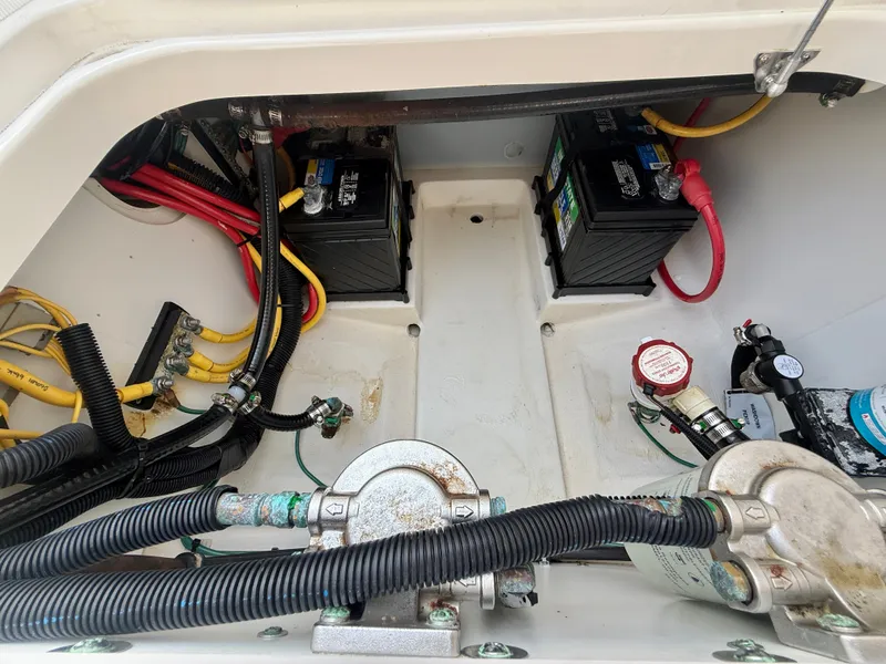 Slide: The Image of The engine compartment of a 2019 Pursuit DC 265 Dual Console shows batteries and wiring. - 30