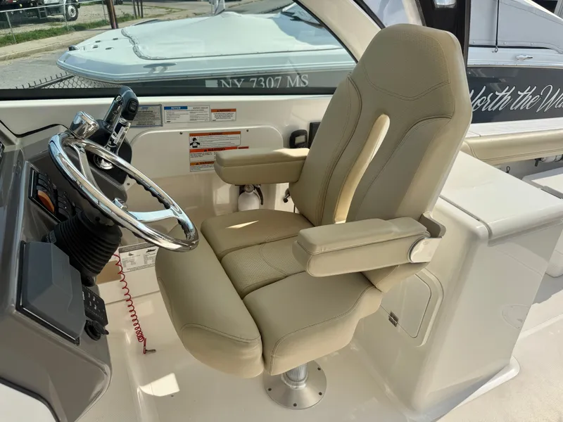 Slide: The Image of A beige captain's chair on a 2019 Pursuit DC 265 Dual Console boat. - 19