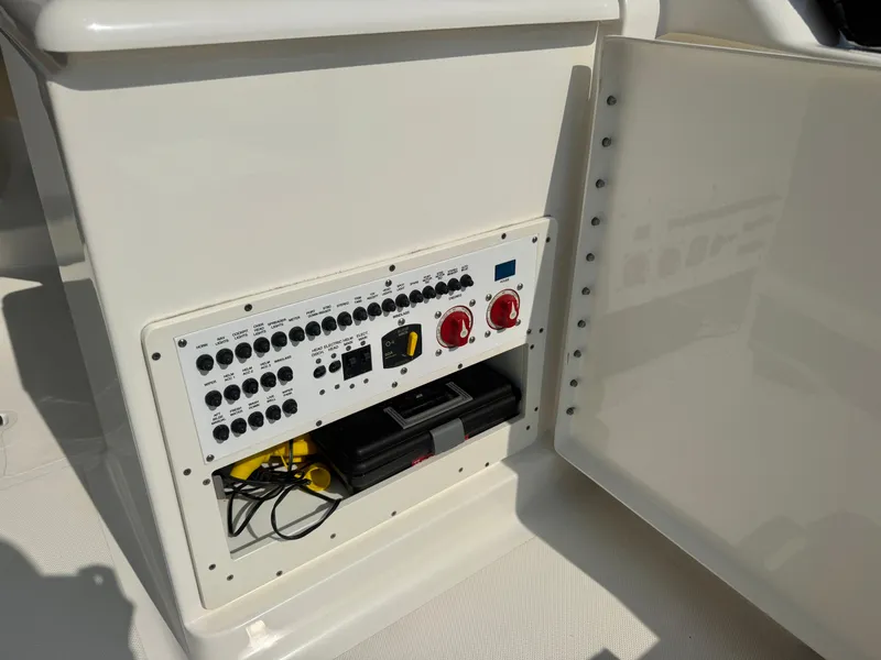 Slide: The Image of A control panel with switches and knobs on a boat, partially covered by a door. - 13