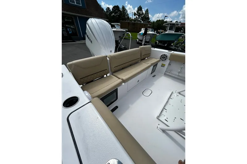 Slide: The Image of 2026 Sportsman Heritage 231 Center Console boat interior with beige seating and storage compartments. - 7
