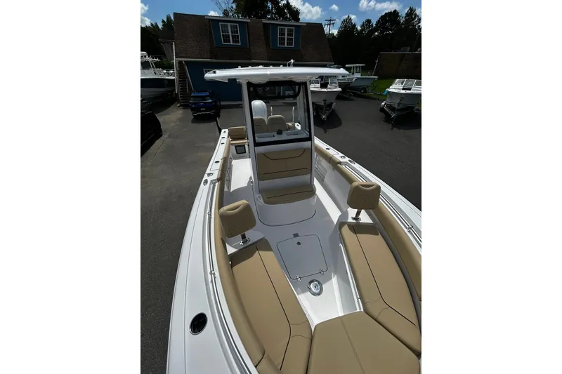 Slide: The Image of 2026 Sportsman Heritage 231 Center Console boat with tan seating, docked outdoors. - 3