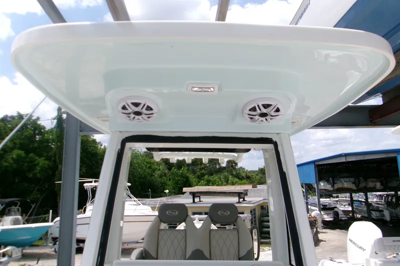 Slide: The Image of 2026 Key West 239 FS boat with speakers on the overhead console, docked outdoors. - 11
