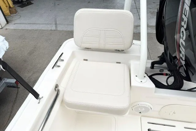 Slide: The Image of 2027 Boston Whaler 170 Montauk boat interior with cushioned seating and Mercury engine. - 10