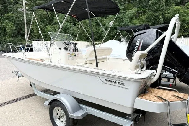 Slide: The Image of 2027 Boston Whaler 170 Montauk boat on trailer, featuring a Mercury outboard motor. - 2