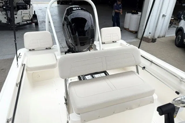 Slide: The Image of 2027 Boston Whaler 170 Montauk boat interior with seating and motor, in a garage setting. - 9