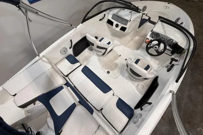 Slide: The Image of 2021 Tahoe 450 TS boat interior with white and blue seating, steering wheel, and dashboard. - 6