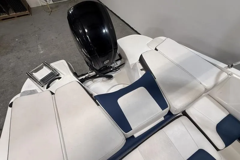 Slide: The Image of 2021 Tahoe 450 TS boat interior with white and blue seating, outboard motor, and ladder. - 7