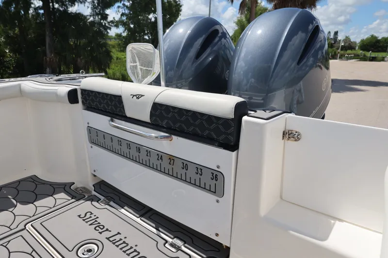 Slide: The Image of 2021 Tidewater 256 CC Adventure boat with dual engines and measuring ruler on deck. - 14