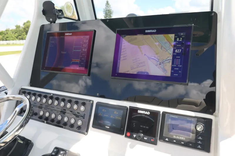 Slide: The Image of 2021 Tidewater 256 CC Adventure dashboard with Simrad navigation displays and control panel. - 8