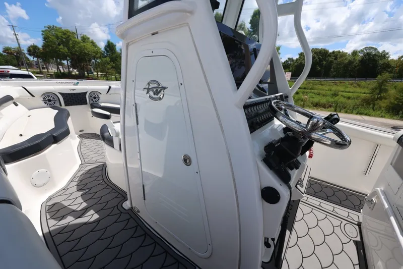 Slide: The Image of 2021 Tidewater 256 CC Adventure boat interior with steering wheel and seating area. - 17
