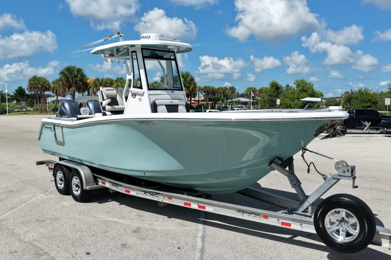 Slide: The Image of 2021 Tidewater 256 CC Adventure boat on trailer under blue sky. - 3