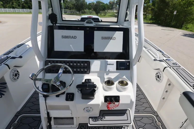 Slide: The Image of 2021 Tidewater 256 CC Adventure boat console with Simrad displays and steering wheel. - 7