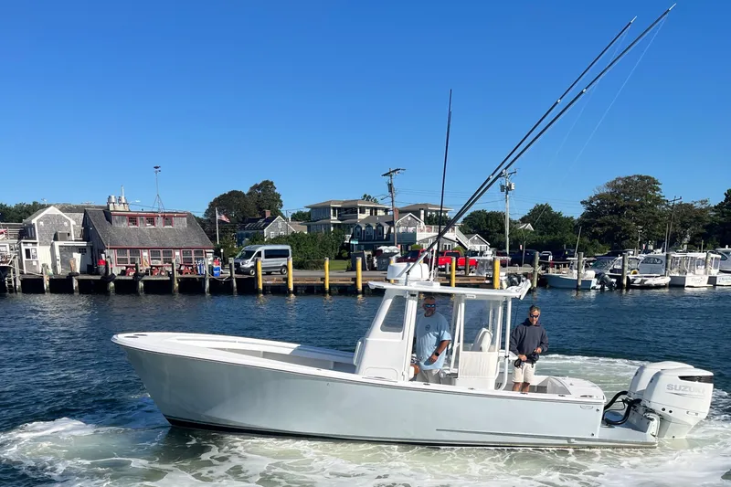Slide: The Image of 2022 Tidal Creeks Boatworks Center Console cruising near a scenic harbor with waterfront buildings. - 19