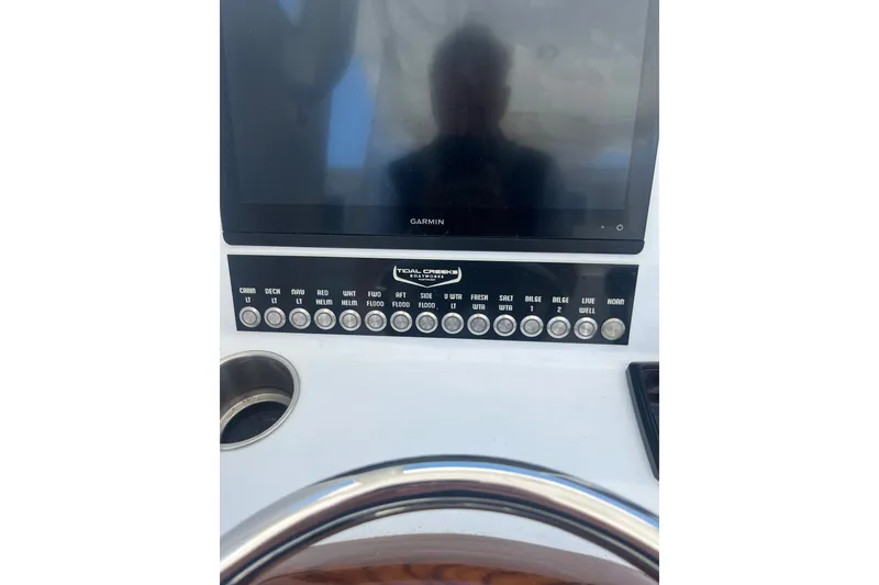 Slide: The Image of Center console controls of 2022 Tidal Creeks Boatworks, featuring Garmin display and labeled buttons. - 16