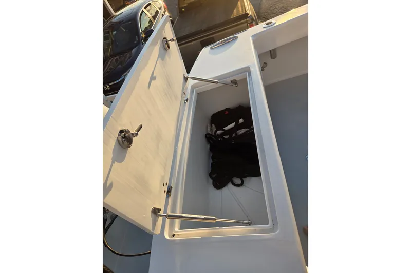 Slide: The Image of 2022 Tidal Creeks Boatworks Center Console storage compartment with open lid and gear inside. - 36