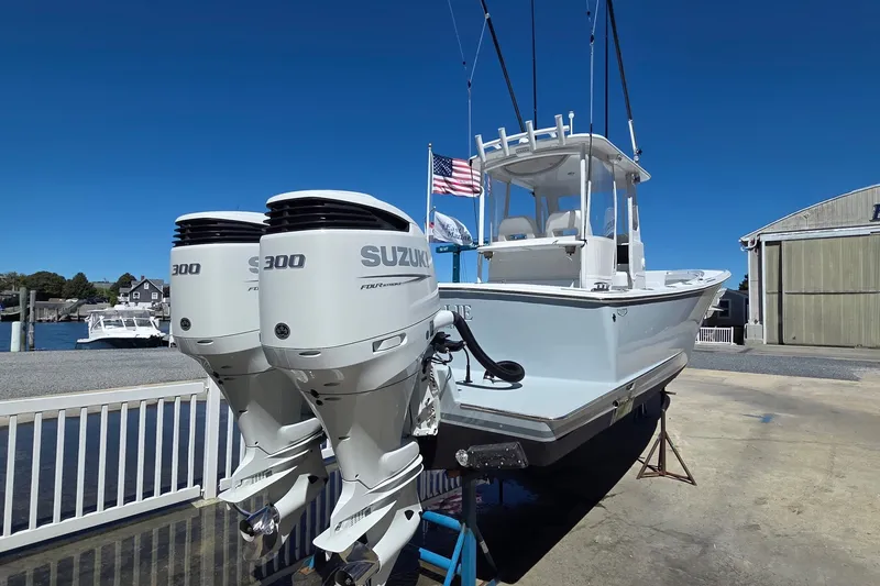 Slide: The Image of 2022 Tidal Creeks Boatworks Center Console with dual Suzuki 300 engines, docked outdoors. - 22