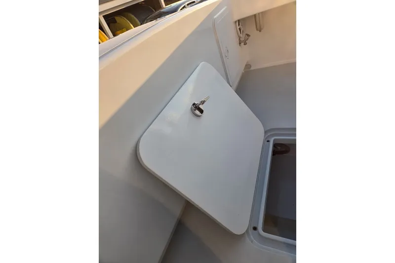 Slide: The Image of 2022 Tidal Creeks Boatworks Center Console storage compartment with open hatch and key. - 35