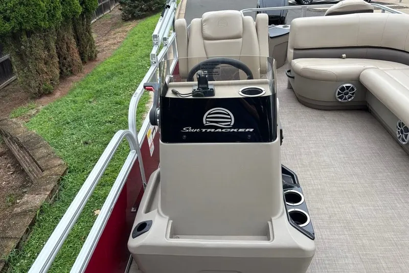Slide: The Image of 2024 Sun Tracker Bass Buggy 18 DLX pontoon boat interior with steering console and seating. - 23