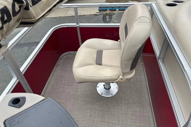 Slide: The Image of 2024 Sun Tracker Bass Buggy 18 DLX boat interior with beige captain's chair and red accents. - 14