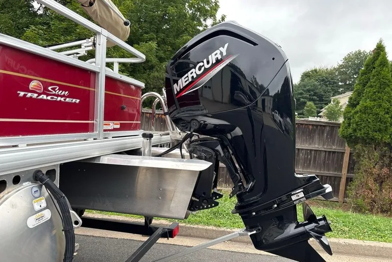 Slide: The Image of 2024 Sun Tracker Bass Buggy 18 DLX with Mercury outboard motor, parked outdoors. - 20