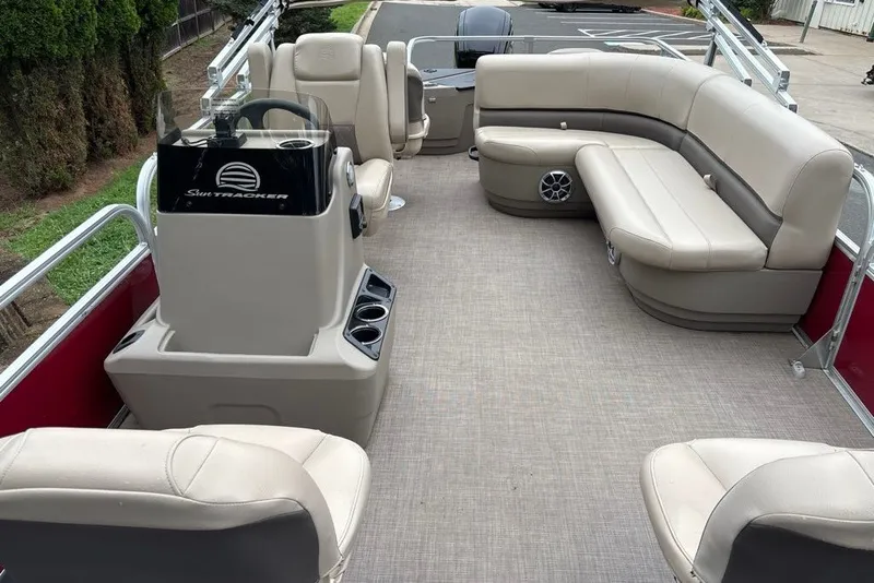 Slide: The Image of 2024 Sun Tracker Bass Buggy 18 DLX pontoon boat interior with beige seating and steering console. - 29