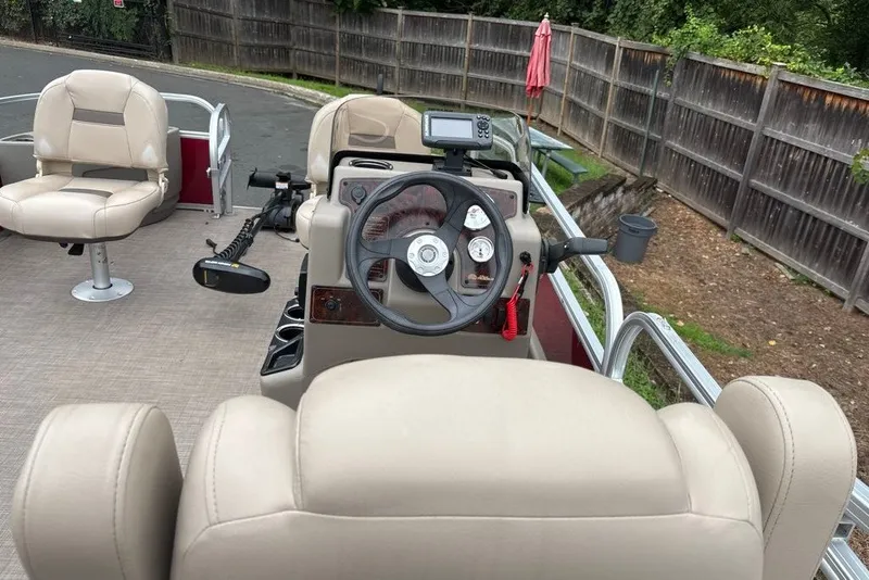 Slide: The Image of 2024 Sun Tracker Bass Buggy 18 DLX pontoon boat interior with steering console and seating. - 19