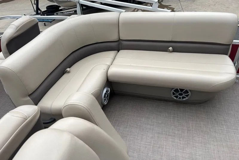 Slide: The Image of 2024 Sun Tracker Bass Buggy 18 DLX interior with beige seating and speaker system. - 16