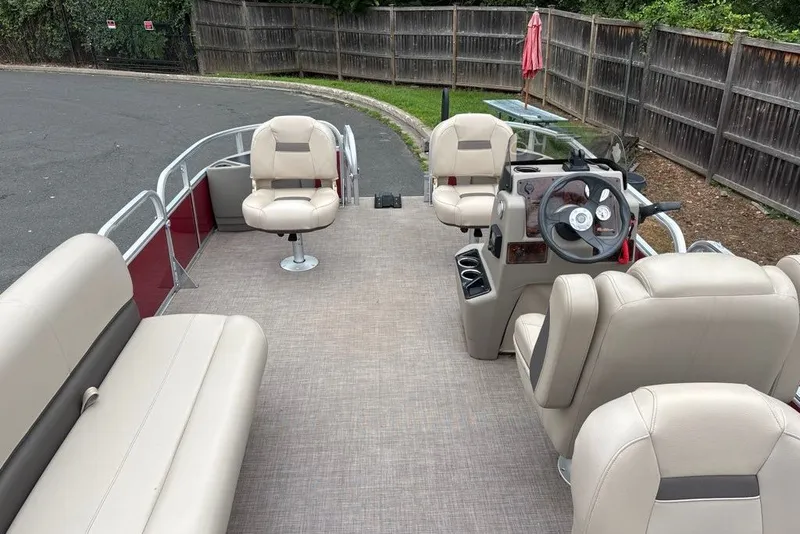 Slide: The Image of 2024 Sun Tracker Bass Buggy 18 DLX pontoon boat interior with beige seating and steering console. - 31