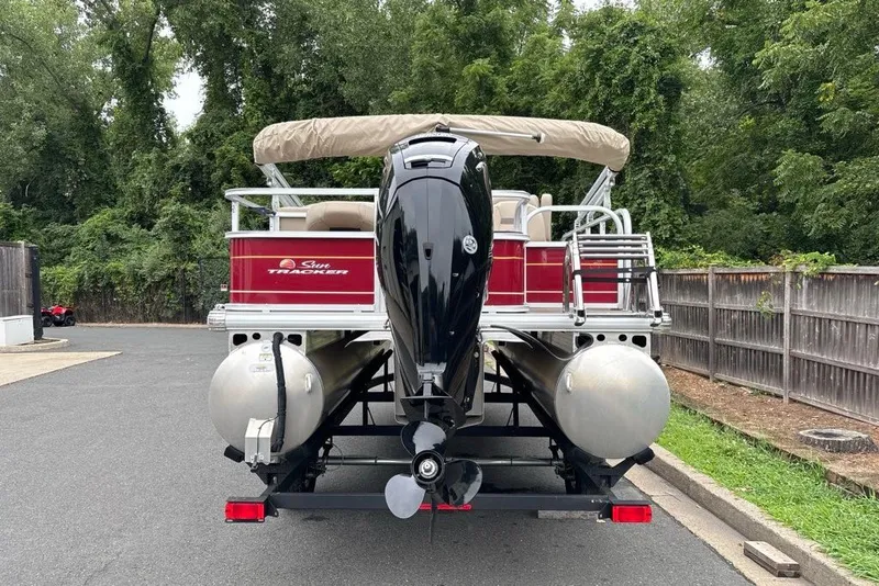 Slide: The Image of 2024 Sun Tracker Bass Buggy 18 DLX pontoon boat, rear view, parked on trailer. - 33