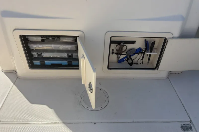Slide: The Image of Storage compartments on a 2021 Grady-White Canyon 306 boat, featuring organized tools and gear. - 12