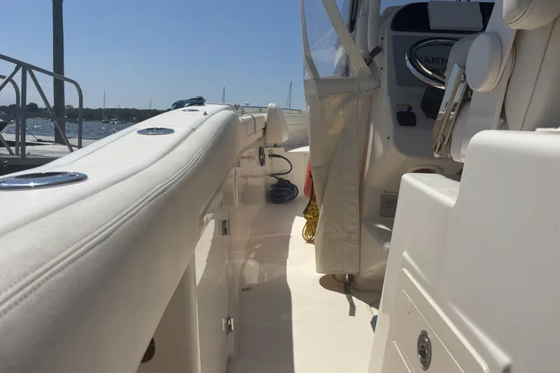 Slide: The Image of 2021 Grady-White Canyon 306 boat interior with sleek white seating and controls. - 16