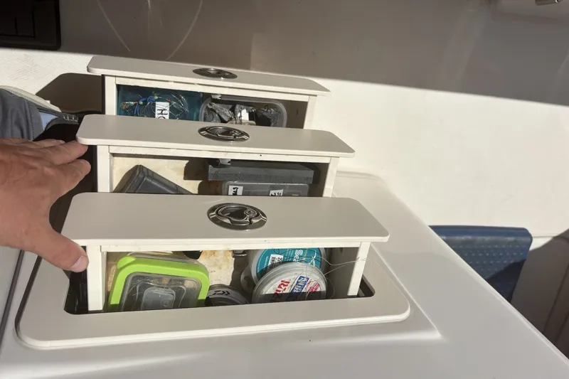 Slide: The Image of Storage compartments on a 2021 Grady-White Canyon 306 boat, filled with fishing gear. - 18