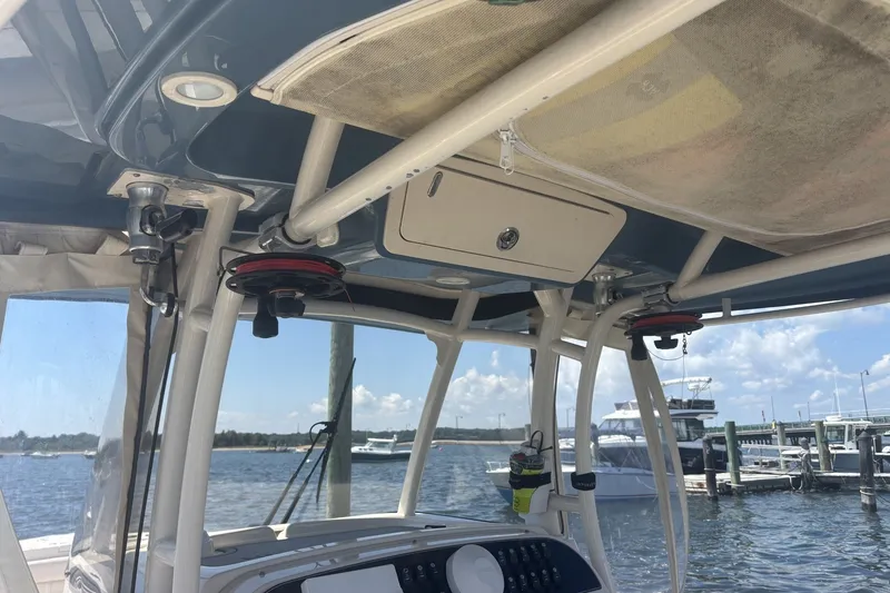 Slide: The Image of 2021 Grady-White Canyon 306 boat interior with console and rod holders at marina. - 7